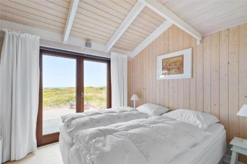 a bedroom with two beds and a large window at 12292-Sjaellands-Odde-Lyngbugten-10 in Yderby