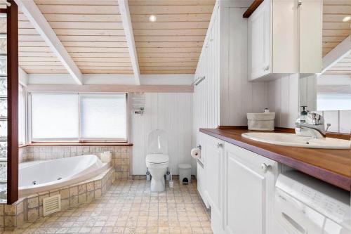 a bathroom with a tub and a toilet and a sink at 12292-Sjaellands-Odde-Lyngbugten-10 in Yderby