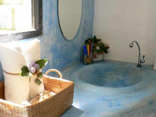 a blue bathroom with a tub with a mirror at Brassiere Beach Hotel in Baanphakrimlay 