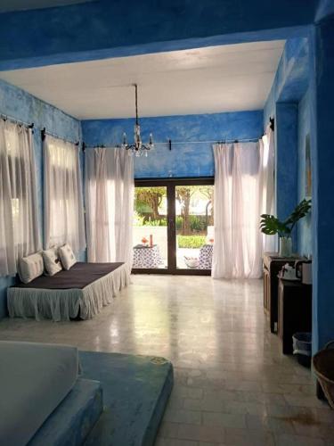 a bedroom with a bed in a blue room at Brassiere Beach Hotel in Baanphakrimlay 