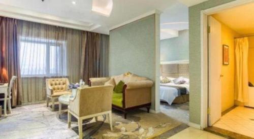 a hotel room with a bed and a living room at Changchun Global Hotel in Changchun