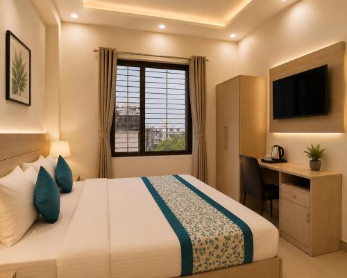 a hotel room with a bed and a desk and a window at Hotel The Vertigo in Noida