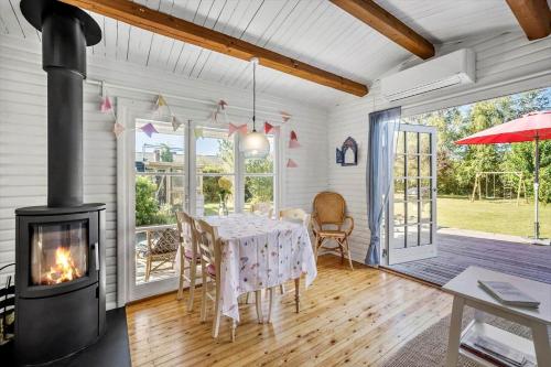 a dining room with a table and a fireplace at FJ1401-Jaegerspris-Hovdiget-5 in Jægerspris