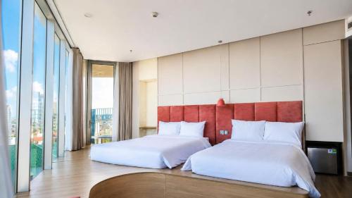a bedroom with two beds and a red headboard at Solia Hill Hotel in Dong Hoi