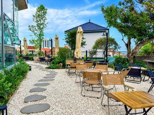 a patio with tables and chairs and a table and chairs at Solia Hill Hotel in Dong Hoi