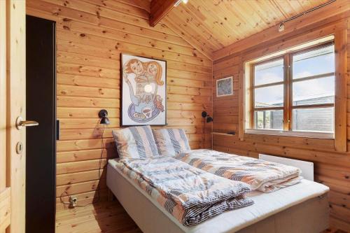 a bedroom with a bed in a wooden cabin at FJ4306-Oro-Skovhojgardsvej-3 in Orø