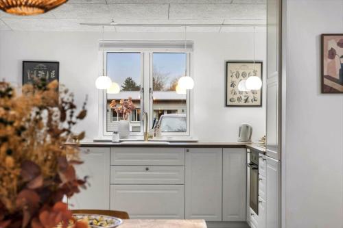 a kitchen with white cabinets and a window at FJ1202-Jaegerspris-Lille-Engvej-7 in Jægerspris