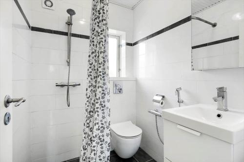 a white bathroom with a toilet and a sink at FJ2403-Skibby-Hybenvaenget-27 in Skibby