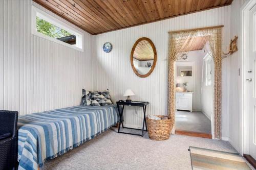 a bedroom with a bed and a mirror at FJ4307-Oro-Gronnevej-6 in Orø