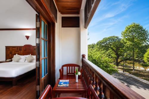 a room with a balcony with a bed and a window at Pierre Hotel in Siem Reap