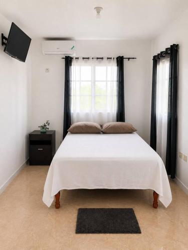 a bedroom with a large white bed with black curtains at The Hideaway Suite, largest master, ocean glimpse in Florence Hall
