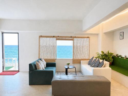 a living room with two couches and a view of the ocean at Gao Check in Phala Beach Front in Rayong