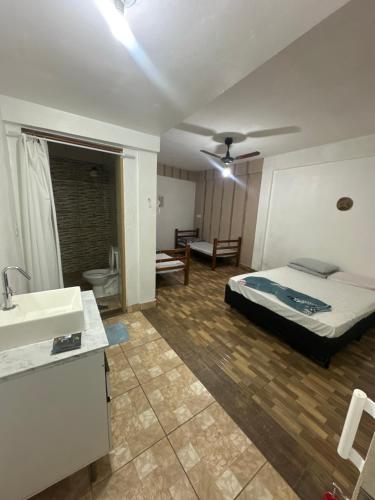 a bedroom with a bed and a sink in it at Pousada Peruibe Praia Centro in Peruíbe