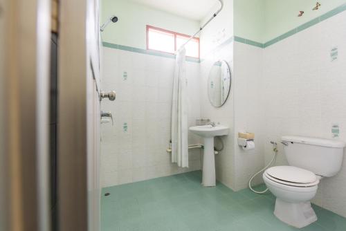 a bathroom with a toilet and a sink at Pachumas Hotel in Karon Beach