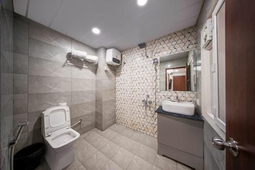 a bathroom with a toilet and a sink at Harvey's Hotel in Hyderabad