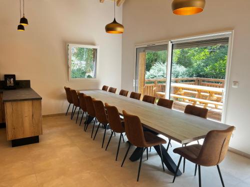 a conference room with a long table and chairs at Chalet des Épicéas - babyfoot billard & PS in Gérardmer