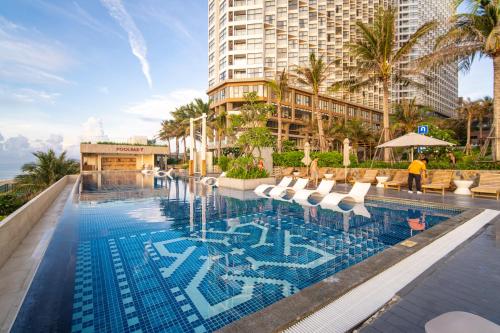 a pool at a hotel with chairs and a building at Mandala Twilight Haven 5 Star in Phan Thiet