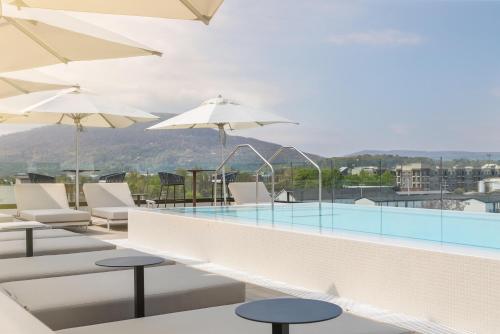 a pool with chairs and umbrellas on a building at Caption By Hyatt Chattanooga Downtown in Chattanooga