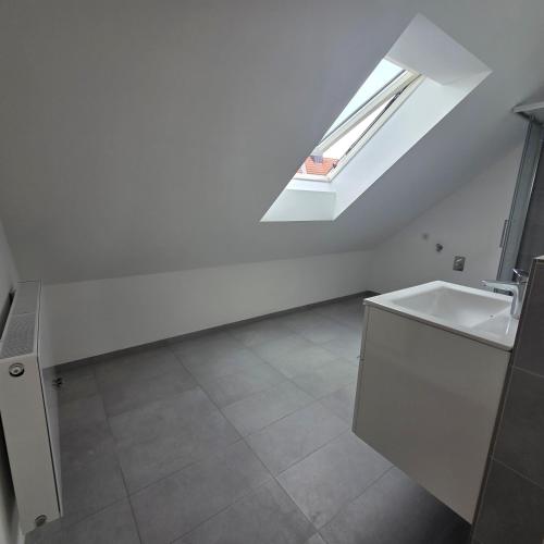 a white bathroom with a sink and a skylight at schöne Neubau Ferienwohnung "Wiesent" mit Küche und Balkon in Forchheim
