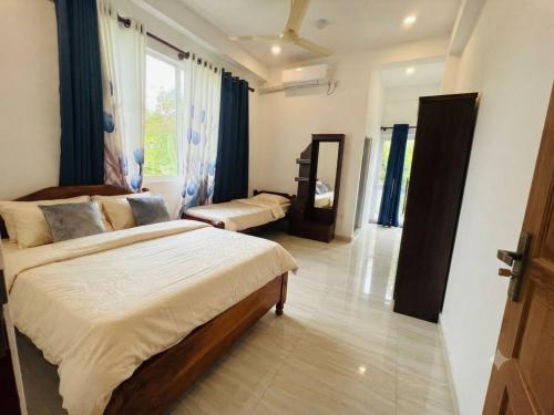 a bedroom with two beds and a large window at msm diamond villa in Ragama