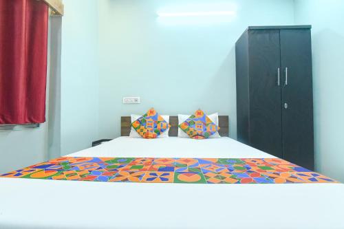a bedroom with a bed with a colorful comforter at FabHotel Taj Palace in kolkata