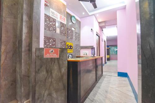 a lobby with a counter and a sign on the wall at FabHotel Taj Palace in kolkata