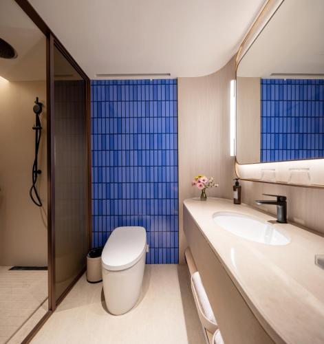 a bathroom with a toilet and a sink at Orange Crystal Hotel Kunming Wanda Plaza in Kunming
