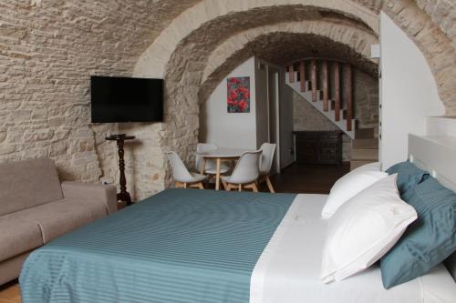 a bedroom with a bed and a couch and a table at Suites Anita in Ruvo di Puglia