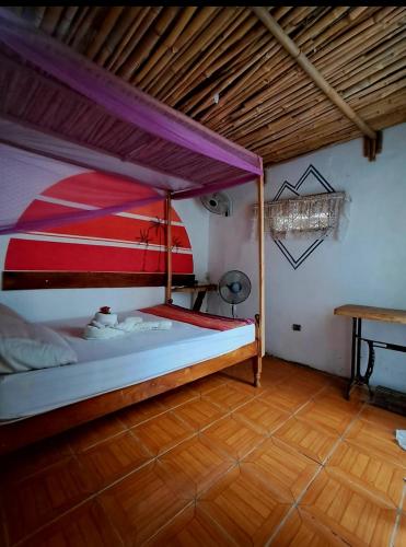 a bedroom with a bed and a wooden floor at TiKi Hostel Island Ometepe in Rivas