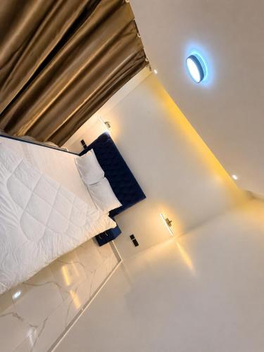 a bedroom with a large bed and a spotlight at KIGALi WHITE HOMES AND RESIDENCE in Kigali