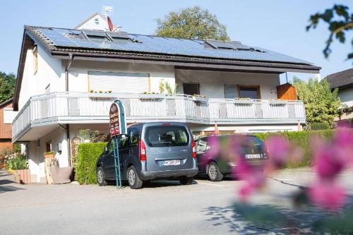 two cars parked in front of a house at Gästehaus Schechter in Uhldingen-Mühlhofen
