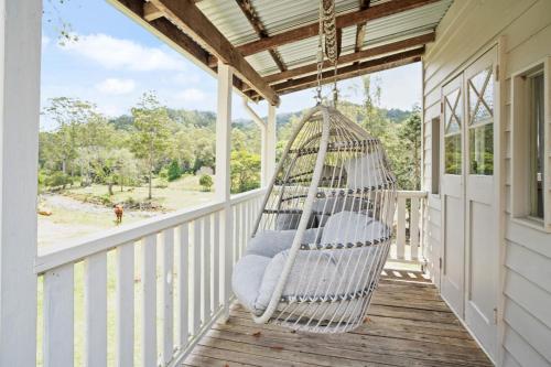 a porch with a hammock on a house at Bellbird Rise Off-Grid Cottage in Conondale