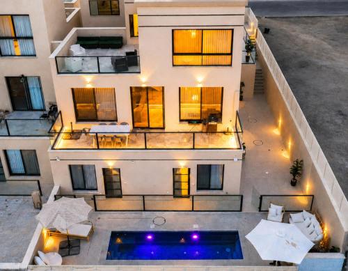 an aerial view of a building with a swimming pool at ריזורט האחוזה- וילה עם בריכה פרטית וסוויטות עם בריכה משותפת מול נוף ים המלח in Neve Zohar