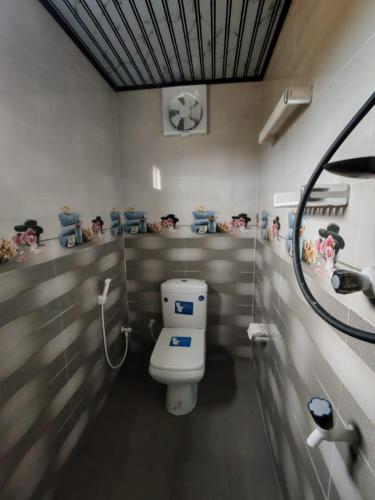 a bathroom with a toilet and a soccer ball on the wall at VIN Solara Farm Stay in Jaffna