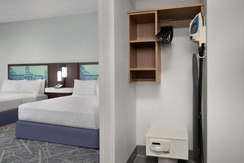 a room with a bedroom with a bed and a refrigerator at Hampton Inn & Suites Lake City in Lake City