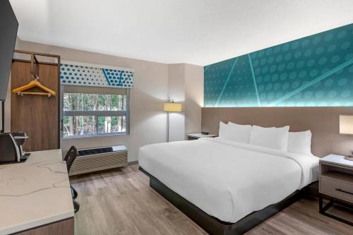 a hotel room with a large white bed and a window at Comfort Inn in Bracebridge