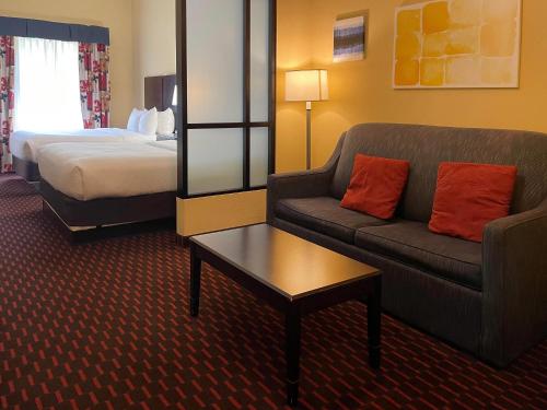 a hotel room with a couch and a bed at Comfort Suites Altoona North in Altoona