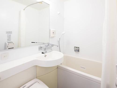 a bathroom with a sink and a toilet and a mirror at Comfort Hotel Naha Prefectural Office in Naha