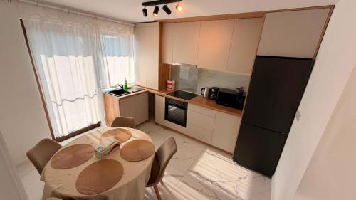 a kitchen with a table with chairs and a refrigerator at Matei Rent Apartments - Premium Stays & Free Parking in Baia Mare