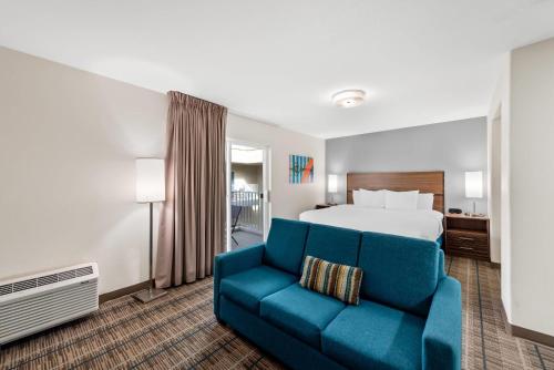 a hotel room with a bed and a blue couch at MainStay Suites El Centro I-8 in El Centro