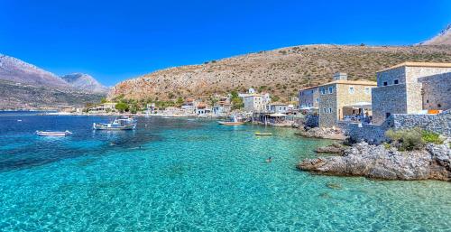 a group of boats in the water next to buildings at Selinitsa Stone Studio - Mani Seaview Retreat in Agios Nikolaos