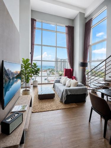 a living room with a couch and a tv at Luxury Seaview 2BR Suite Near Georgetown Maritime Penang 0706 in George Town