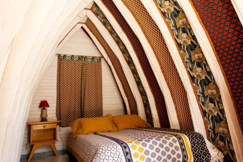 a bed in a room with an american flag wall at Les roulottes de Rita "Le poulailler" in Verfeil-sur-Seye