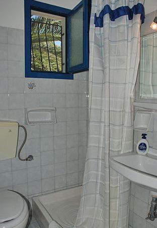 a bathroom with a toilet and a sink at Villa Fiorita in Paleokastritsa