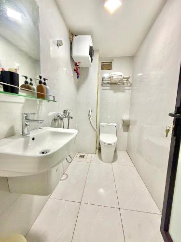 a white bathroom with a sink and a toilet at Khách sạn Thanh Sơn Nội Bài in Thach Loi