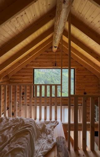 a bed in a wooden room with a window at OHANA Cottages in Merisi in Merisi