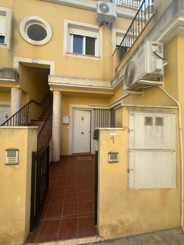 a building with a balcony and a door with a fan at Cuchillos de la fonseca in Casas de Moya