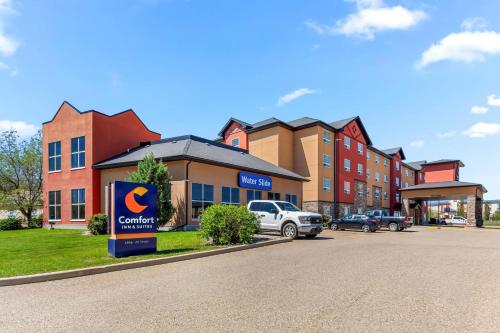 a building with a sign in front of a parking lot at Comfort Inn & Suites Red Deer - Highway 11 in Red Deer
