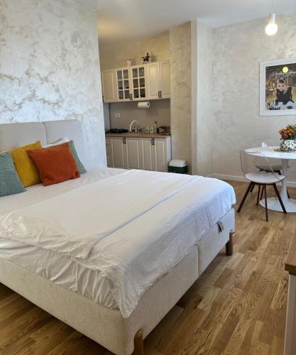 a bedroom with a large bed and a table at Tiffany apartment - Podgorica in Podgorica