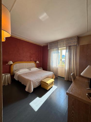 a bedroom with a large bed and a window at Hotel Giglio in Montecatini Terme